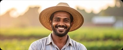 Happy farmer in field wearing straw hat